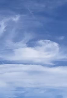 Vivid blue sky with wispy clouds on a sunny day.